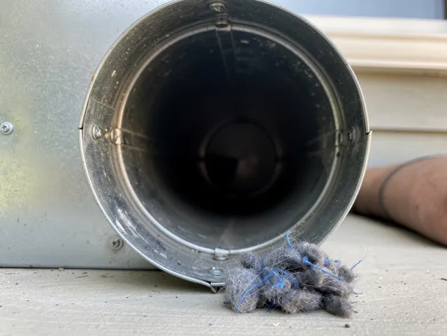 Monroe Dryer Vent Cleaning technician using specialized equipment to clear severe dryer vent blockage in Monroe